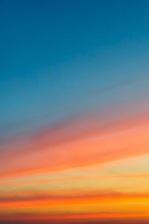 Colorful color of sky (Cloudy sky and orange light of the sun through the clouds with copy space) - vertical viewの写真素材
