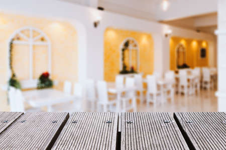 Empty wood table top and blurred cafe or restaurant background.