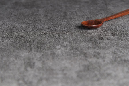 Brown wooden spoon on stone floor.の写真素材