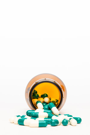 Isolated Amber Drug Bottle and Drug Capsule on White Background.の写真素材