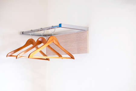 Wooden clothes hangers hanging over a clothesline on a white background, selective focus points