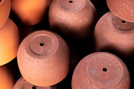 Stacks of orange various terracotta pots for plants for sale at a garden store.の写真素材