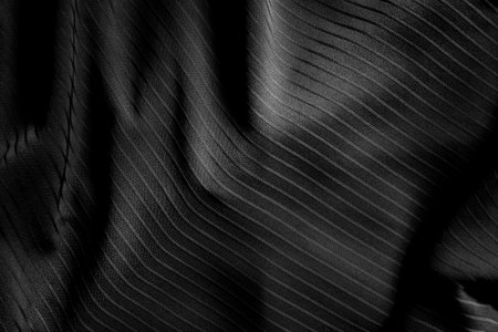 Dark black and gray blurred gradient and line of cloth or fablic background has a little abstract light.の写真素材