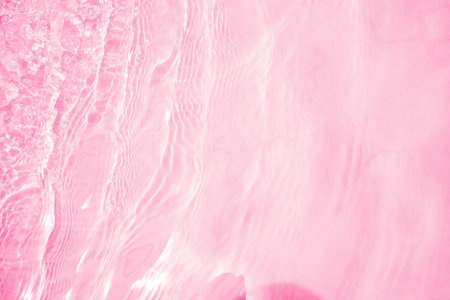 Blurred transparent pink colored clear calm water surface texture with splashes and bubbles. Trendy abstract nature background. Water waves in sunlight. water backgroundの写真素材