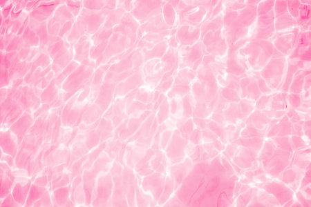 Blurred transparent pink colored clear calm water surface texture with splashes and bubbles. Trendy abstract nature background. Water waves in sunlight. water backgroundの写真素材