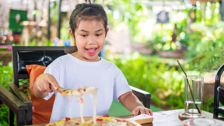 Asian girl wearing white shirt holding triangle shape stainless steel shovel scoop piece of delicious tasty Hawaiian traditional Italian crust thin crispy ham and pineapple pizza up stretching cheeseの写真素材