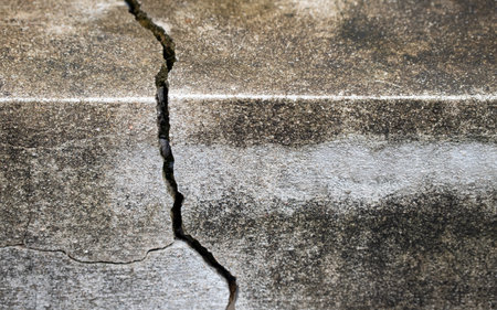 Close-up of Cracked concrete wall texture, Cement background not painted in vintage style for graphic design or retro wallpaper,texture crack in concrete wallの写真素材