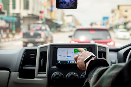 Driver's Hand Using GPS Screen or map During Road Trip, Dangers Of Using Technology While Drivingの写真素材