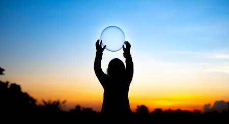 Silhouette of Exuberant children delighting in a water balloon and gold sunset background , a...