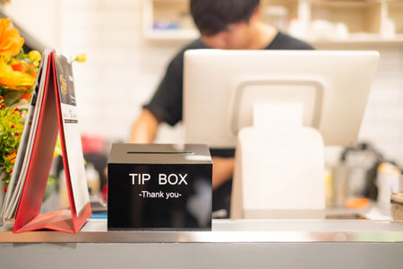 Thank you word  on Black Tip box  for good service on cashier counter in coffee shop.Tips is a sum of money customarily given by a client or customer to a service worker, in addition to the basic priceの写真素材