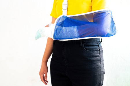 Woman's hand wrapped in white bandage from accident, injury, accident insurance, soft splint on finger, copy spaceの写真素材