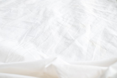 Abstract White Bedding Sheets or White wrinkled fabric background texture and Texture with copy-space :Creased or wrinkled white fabric,Soft focusの写真素材