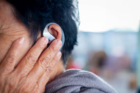 Senior's woman hand touch hearing aid, ear and listening, help and trust, healthcare and medicine.
woman wearing digital hearing aid for sound  noise and communication, Hearing problems in the elderlyの写真素材