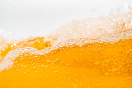 Close up bright orange Oil or beer splash texture and nature waves, Beautiful waves curve and little bubbles smooth for graphic design and background, Oil Bubbles, Soft beer bubbles, Selective focus pointの写真素材
