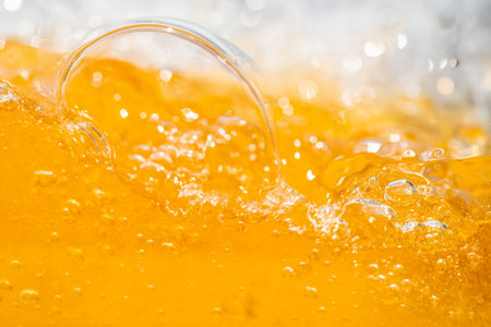 Close up bright orange Oil or beer splash texture and nature waves, Beautiful waves curve and little bubbles smooth for graphic design and background, Oil Bubbles, Soft beer bubbles, Selective focusの写真素材