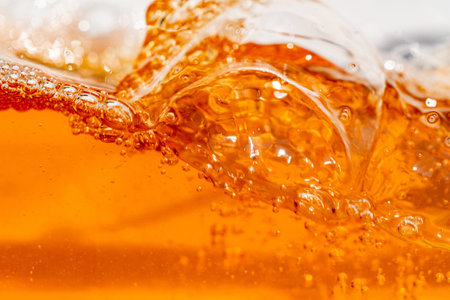 Close up bright orange Oil or beer splash texture and nature waves, Beautiful waves curve and little bubbles smooth for graphic design and background, Oil Bubbles, Soft beer bubbles, Selective focusの写真素材