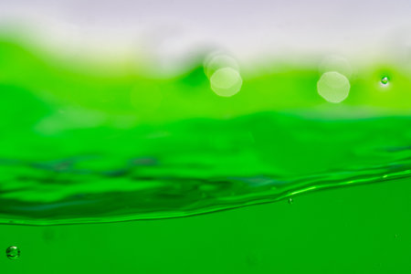 Water wave, close up of vibrant green liquid with bubbles, capturing dynamic movement and freshness. Perfect for backgrounds, beverages, or abstract concepts.の写真素材