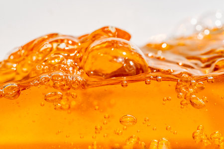 Close up bright orange Oil or beer splash texture and nature waves, Beautiful waves curve and little bubbles smooth for graphic design and background, Oil Bubbles, Soft beer bubbles, Selective focusの写真素材