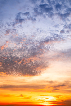 Sky,Beautiful sunset view, luxury soft gradient orange gold clouds and sunlight on the blue dramatic sky perfect for the background, morning, evening,Twilight, climate change,Vertical sunset photoの写真素材