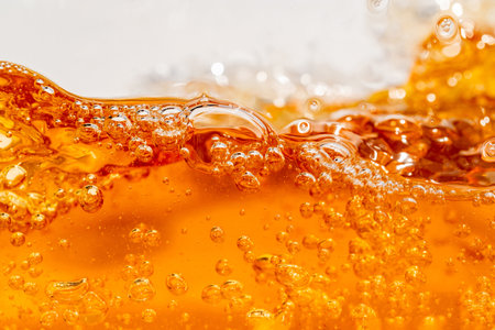 Close up bright orange Oil or beer splash texture and nature waves, Beautiful waves curve and little bubbles smooth for graphic design and background, Oil Bubbles, Soft beer bubbles, Selective focusの写真素材