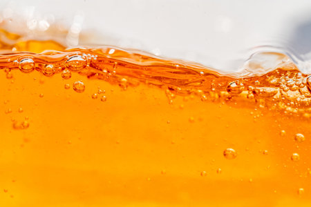 Close up bright orange Oil or beer splash texture and nature waves, Beautiful waves curve and little...