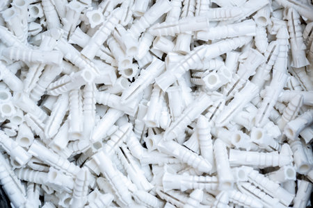 Close-up of white plastic wall plugs used in construction and hardware installation. Essential building materials for fixing screws securely in walls, providing strength, stability, and durability.の写真素材