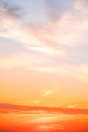 Beautiful , luxury soft gradient orange gold clouds and sunlight on the blue sky perfect for the background, take in evening,Twilight, Large size, high definition landscape photo,Verticalの写真素材