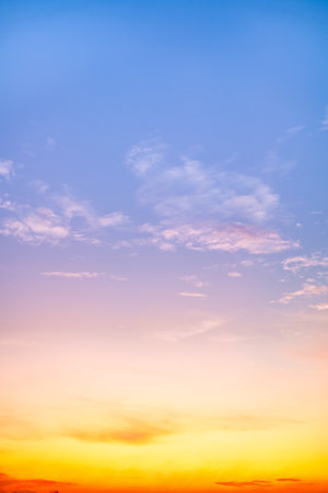 Sunset or sunrise sky with a vibrant gradient of orange, gold, and soft blue. Clear atmosphere with wispy clouds. Peaceful, natural light background. hope, freedom, new day Concepts, Verticalの写真素材
