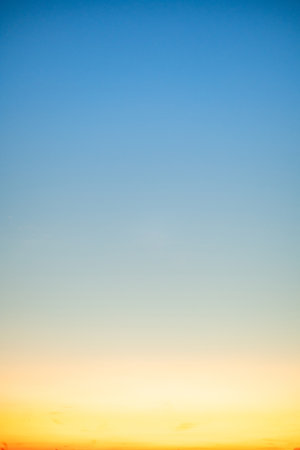 Beautiful soft gradient orange gold clouds and sunlight on the blue sky perfect for the background, take in evening,Twilight, Large size, high definition landscape photo,Verticalの写真素材