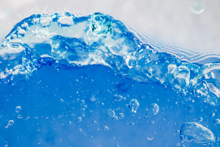 Closeup Transparent blue clear water surface texture with ripples. Abstract of surface blue splashes and bubbles water waves reflected with sunlightの写真素材