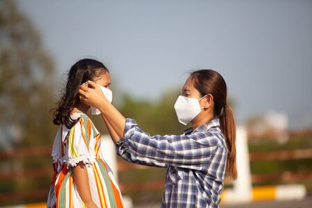 Mother is wearing a mask to protect her corona virus.の写真素材