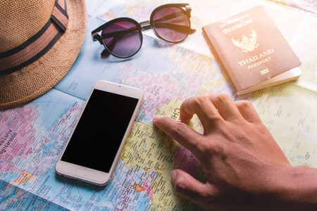 Male Tourist planning with the help of world map with other travel accessories aroundの写真素材