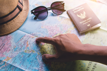 Male travelers plan to travel using a world map and a Thailand passport.の写真素材