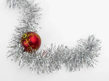 Christmas toy surrounded by tinsel on a white backgroundの写真素材