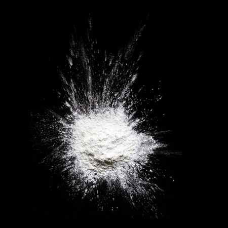 White powder explosion isolated on black backgroundの写真素材