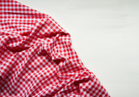 white colored wooden table with red squared textile tablecloth, top view, horizontalの写真素材