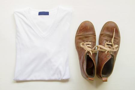 T-shirt with brown leather shoes on wooden floors, white background.の写真素材