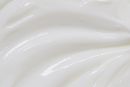 The white surface of the cream lotion softens the background.