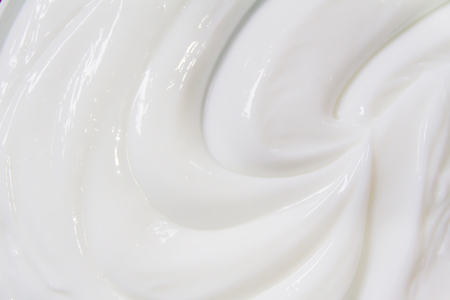 The white surface of the cream lotion softens the background.の写真素材