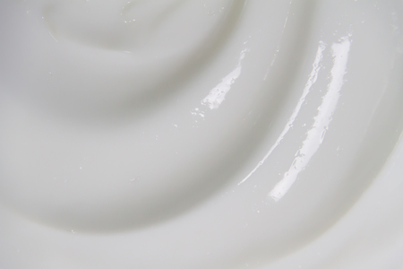 The white surface of the cream lotion softens the background.の写真素材
