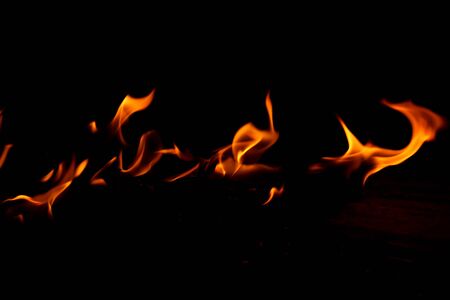 Flame on a wooden pile on a black background.の写真素材