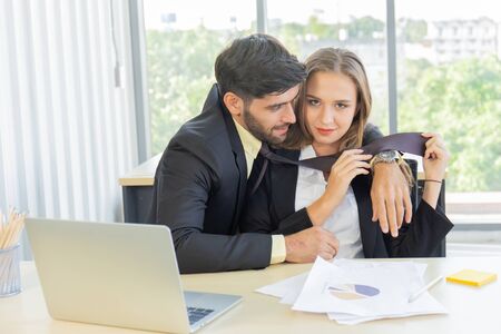 Two young businessmen, men and women, work at the office with a tablet and accompanying documents on...