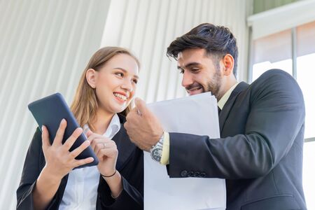 Two business men and women standing meeting in the officeの写真素材