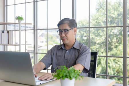 Asian elderly men are learning how to trade online through the Internet.の写真素材