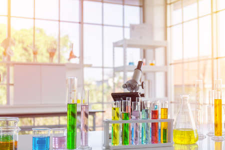 Chemical reagent in scientific experiment flasks of various shapes, sizes and with orange light.