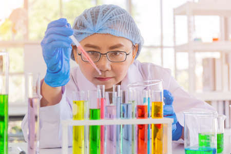 An Asian female scientist is researching a chemical formula in a lab.
