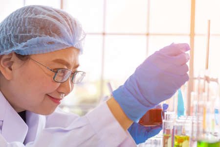 An Asian female scientist is researching a chemical formula in a lab.の写真素材