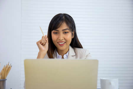 A young Asian professional businesswoman is sleeping on her desk.の写真素材