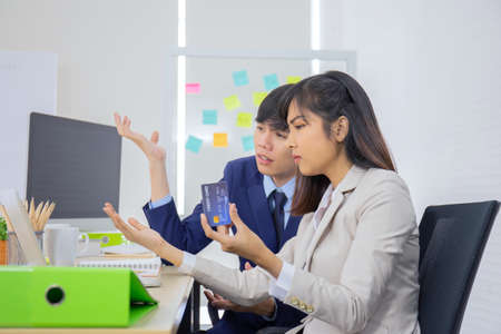 A young professional Asian businesswoman who uses a laptop computer and a credit card to pay online...