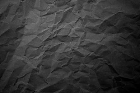 Textured crumpled black paper background.の写真素材